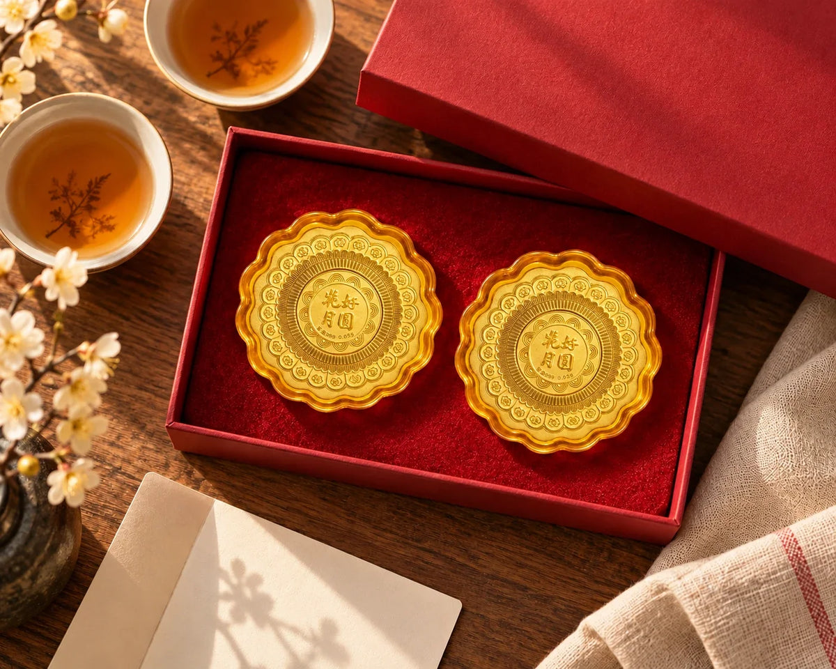 Gold mooncake keepsakes in a presentation box on a table set for tea.