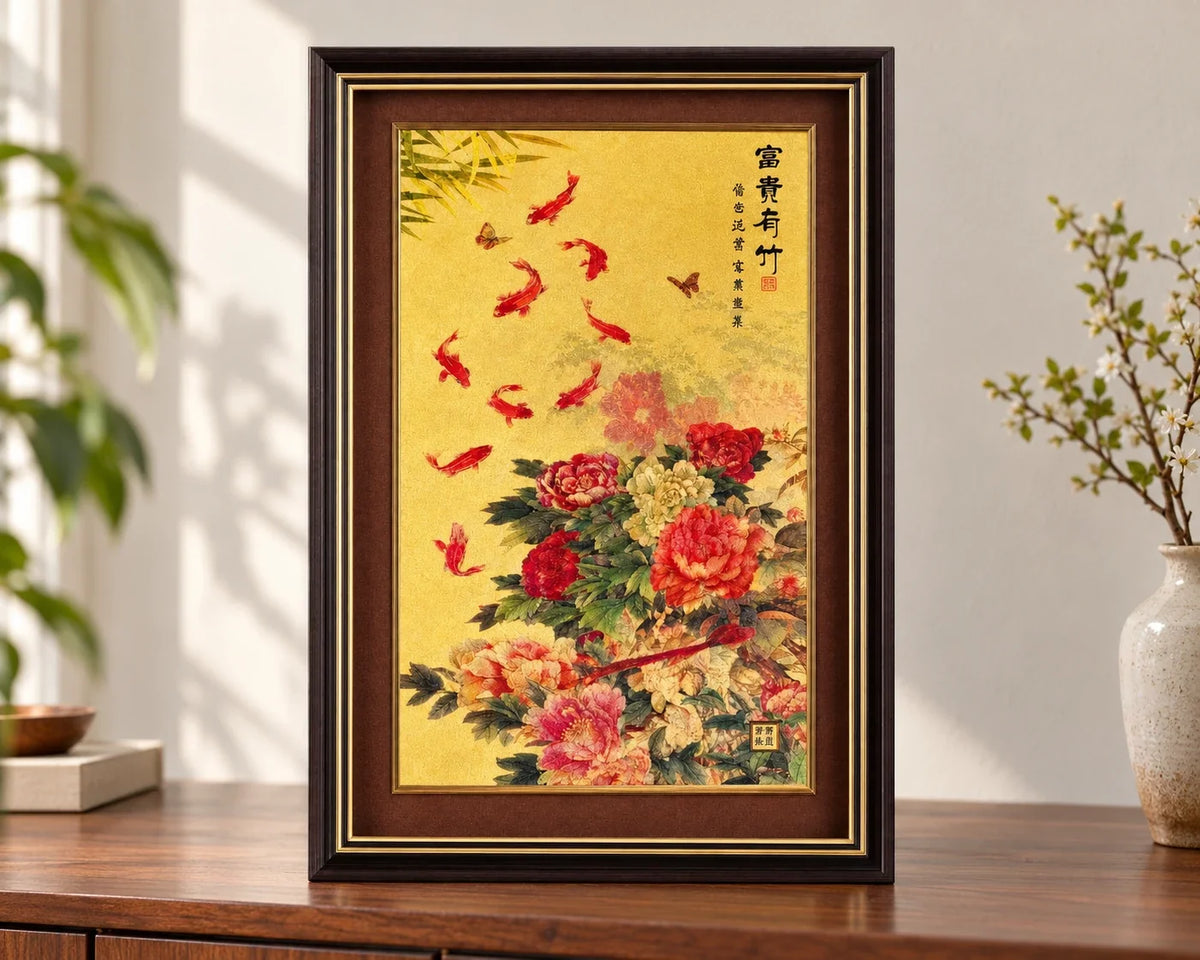 Bamboo and Peony framed gold artwork with fish and floral motifs displayed on a wooden sideboard.
