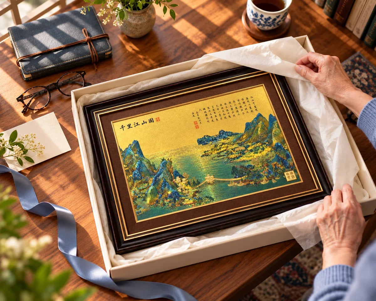 A landscape artwork being unwrapped on a desk beside a notebook.