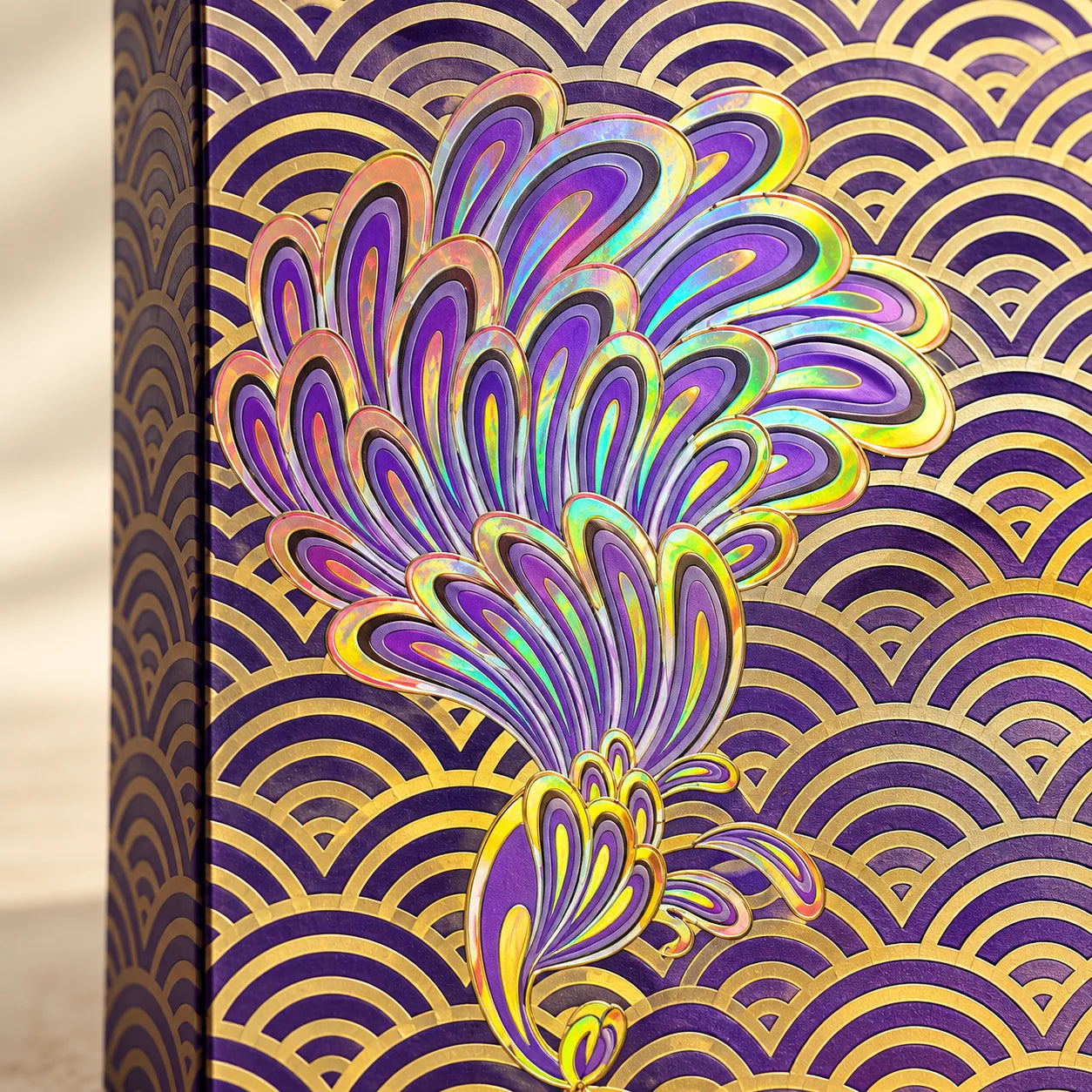 Intentional close view of the purple presentation case's peacock and metallic wave pattern