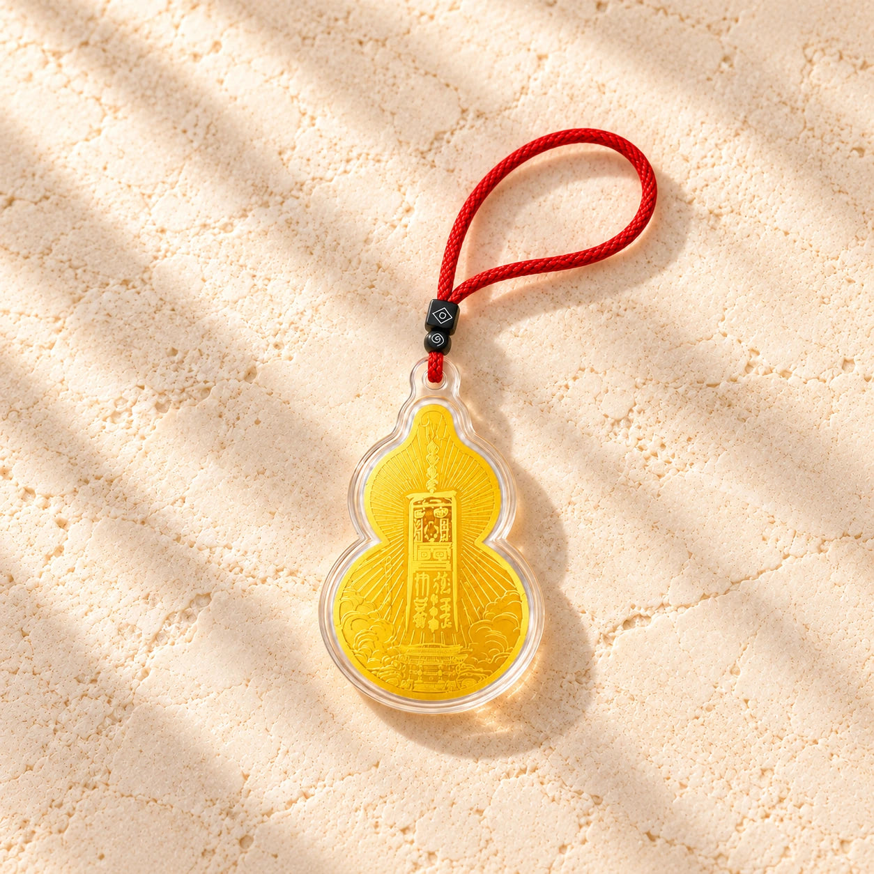 Complete Wudang charm with its red braided cord and black beads arranged in a close product study